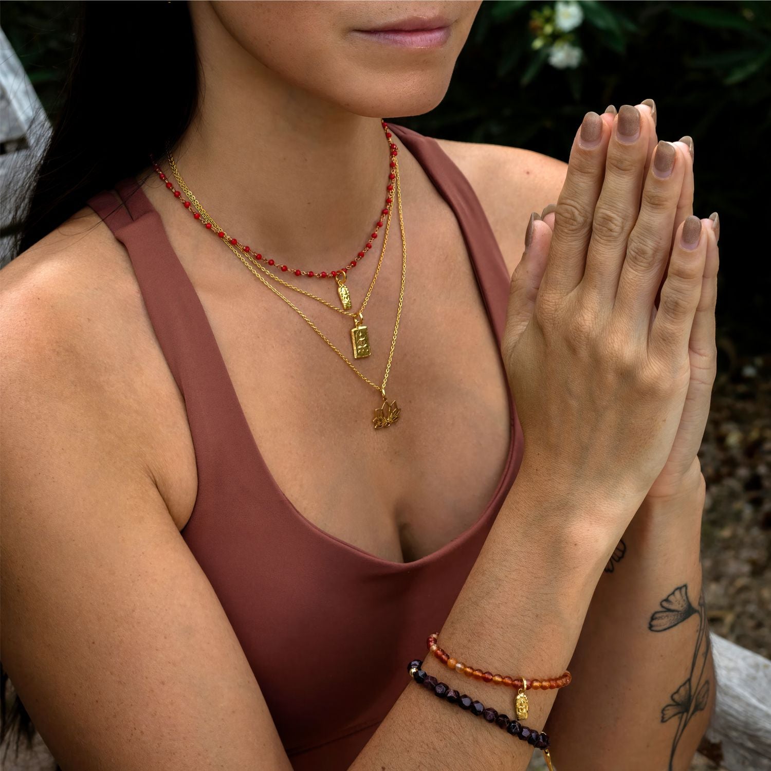 Die balinesisch-deutsche Yoga-Lehrerin Steffi kombiniert ein Buddha-Armband mit Karneol-Edelsteinen mit hochwertig vergoldetem Sterling Silber Anhänger zu einem Granatedelstein-Armband von ETERNAL BLISS