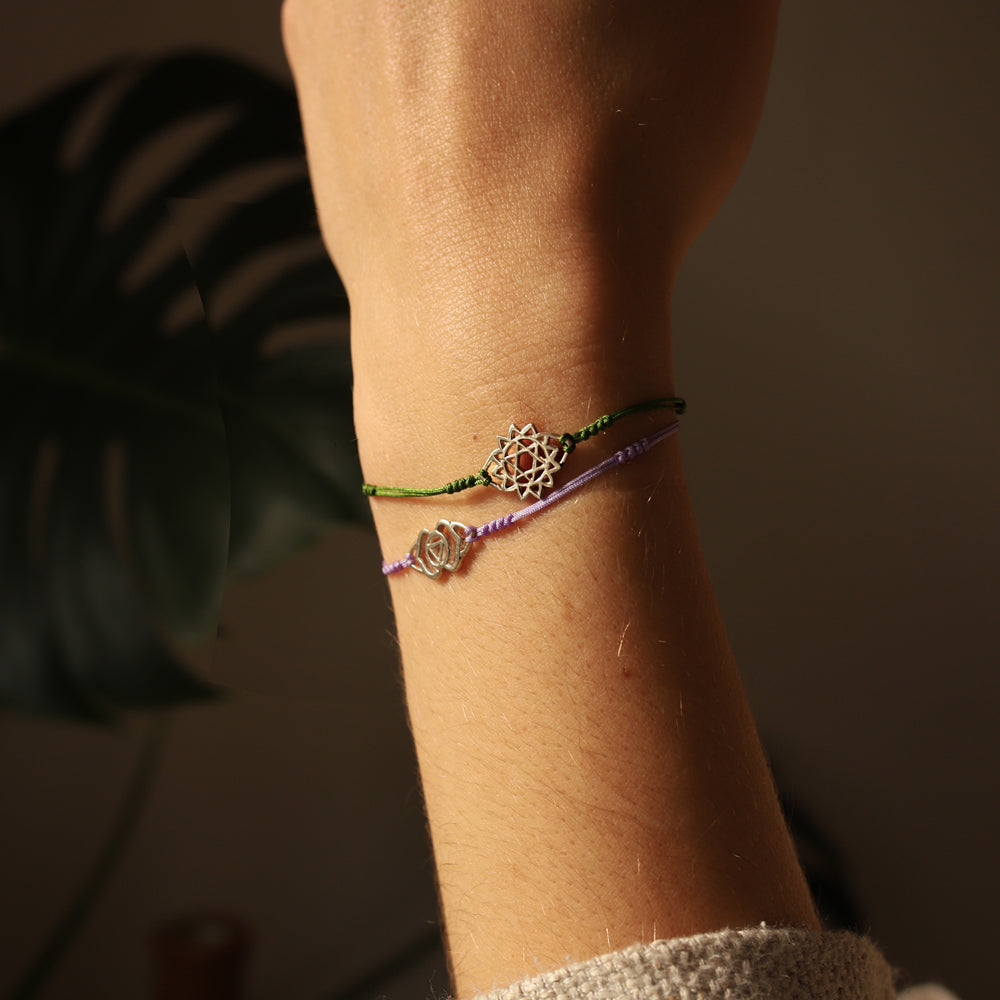 Rasayana zeigt uns an ihrem Handgeleng ein Herzchakraarmband mit grüner Kordel und ein Stirnchakraarmband