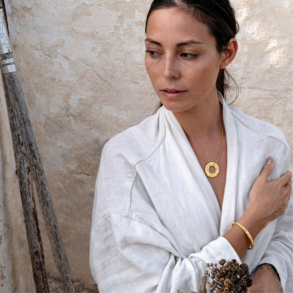 Die Yogalehrerin Steffi trägt zu dem vergoldeten Om-Mani-Padme-Hum-Anhänger aus Sterling Silver einen vergoldeten Tara Mantra Armreif von ETERNAL BLISS