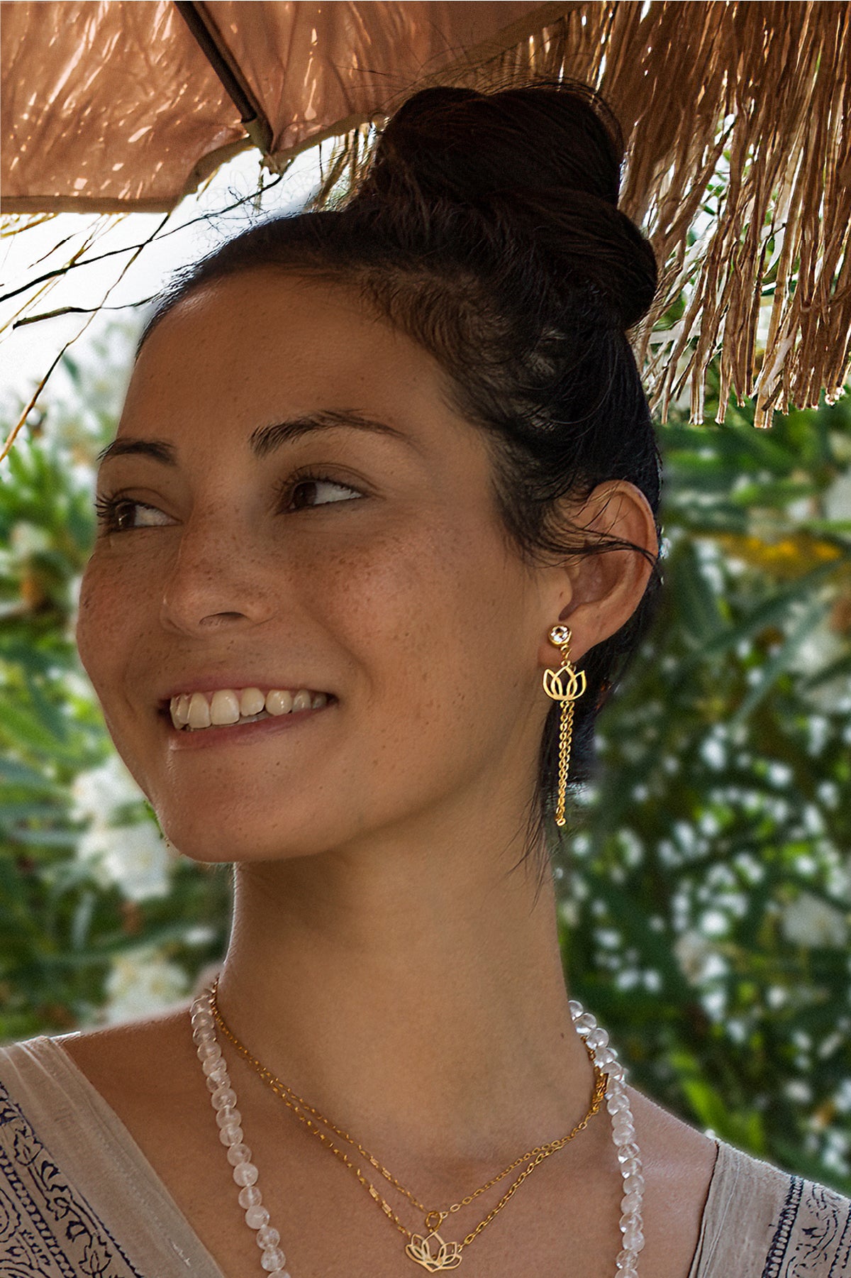 Spiritual jewelry collection: Steffi from Bali wears a gold lotus earring—a symbol of a sense of security—with a gemstone necklace.