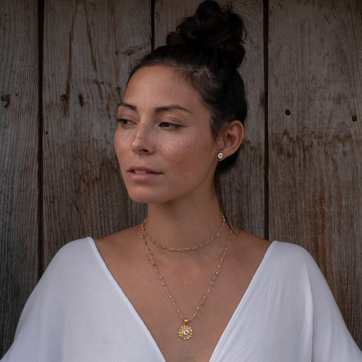 Die Yogalehrerin Steffi kombiniert ein Paar hochwertig vergoldete Bergkristall Ohrstecker mit spirituellem Chakraschmuck von ETERNAL BLISS