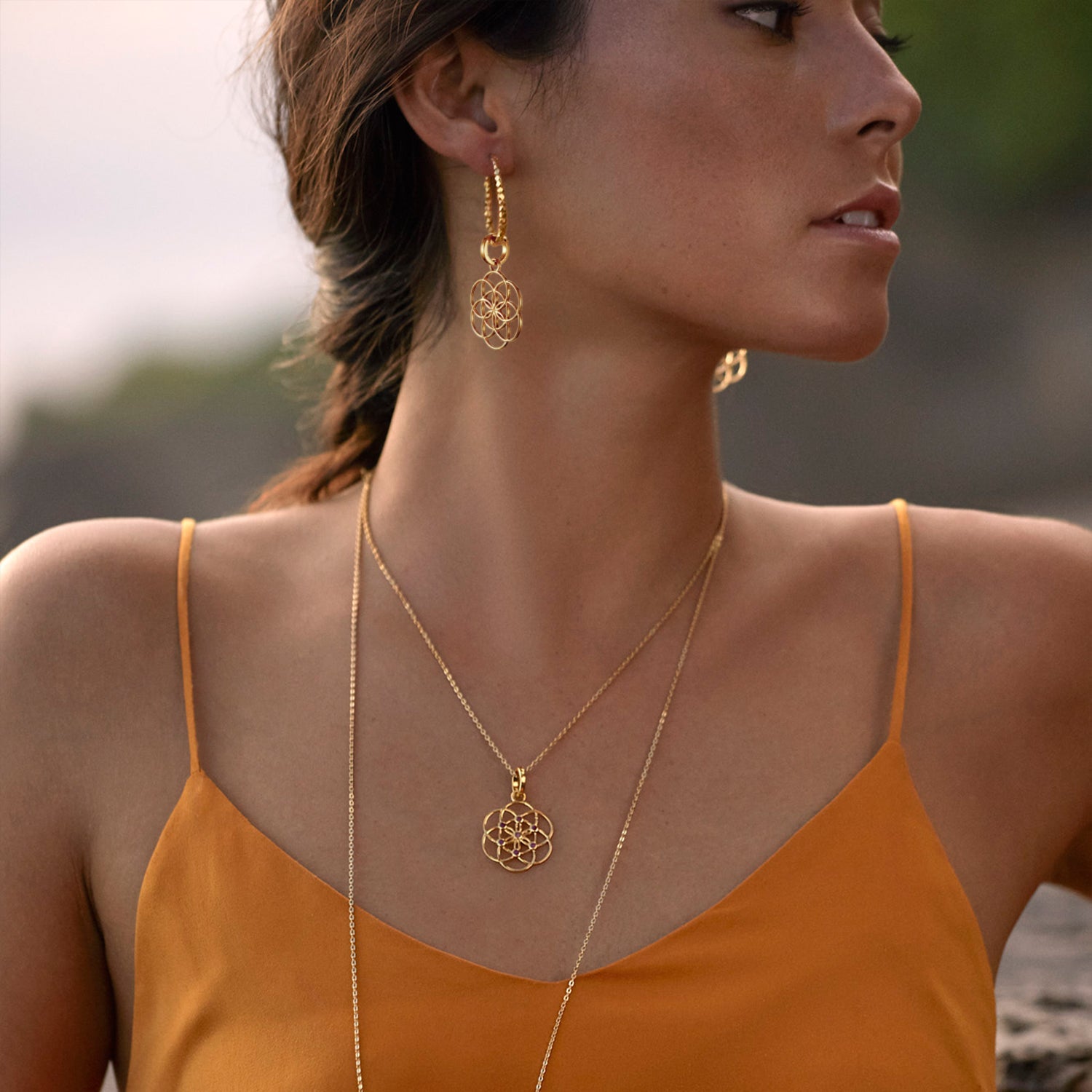 Die Yogalehrerin Steffi trägt die vergoldeten Samen-des-Lebens-Kreolen mit Beads zu euiner Samen-des-Lbens-Kette mit Rubinen