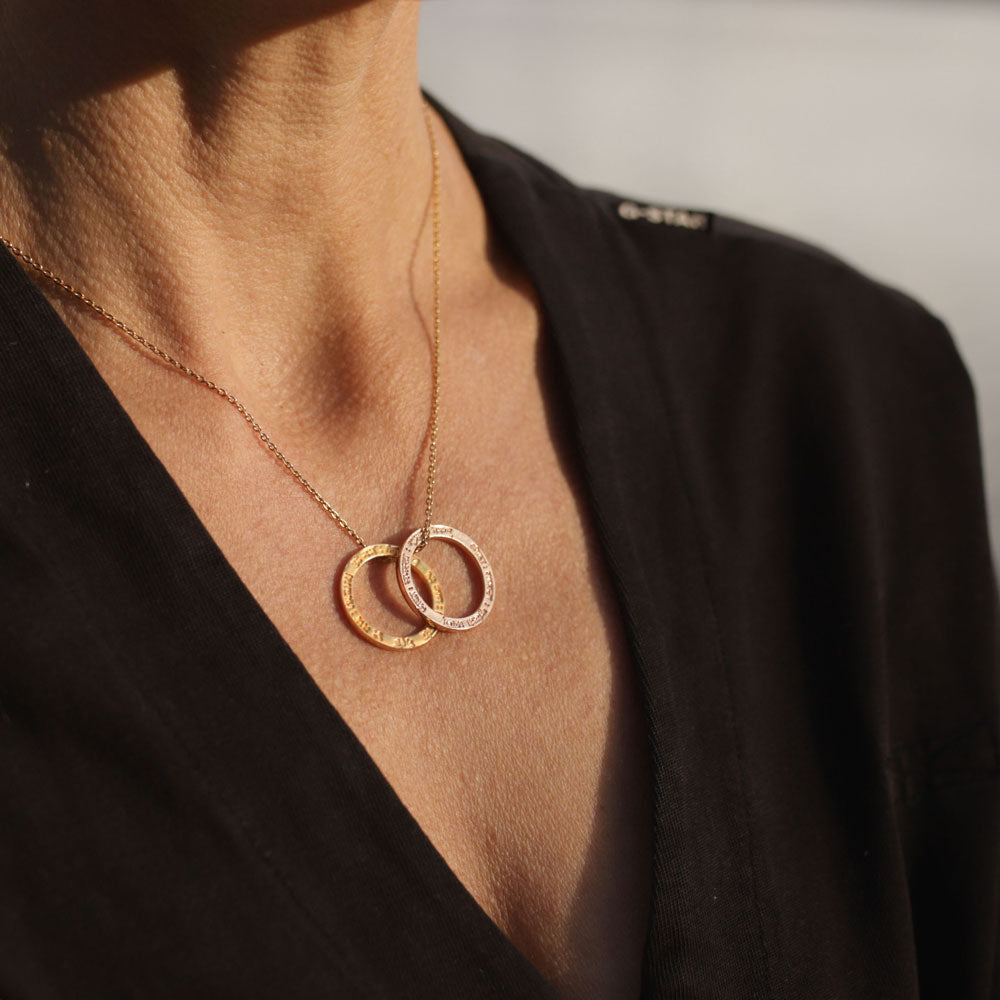 Yoga Teacher Anette Söhnlein trägt einen vergoldeten Lokah-Samastah-Mantra-Anhänger und einen rosévergoldeten von Eternal Bliss