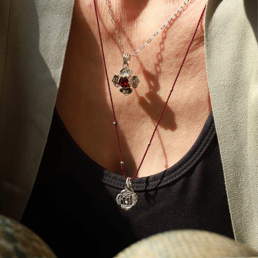 Elena Fröhlich, Yoga Lehrerin in Berlin, kombiniert den kleinen, silbernen Wurzel-Chakra-Anhänger mit dem Wurzel-Chakra-Anhänger mit Granat