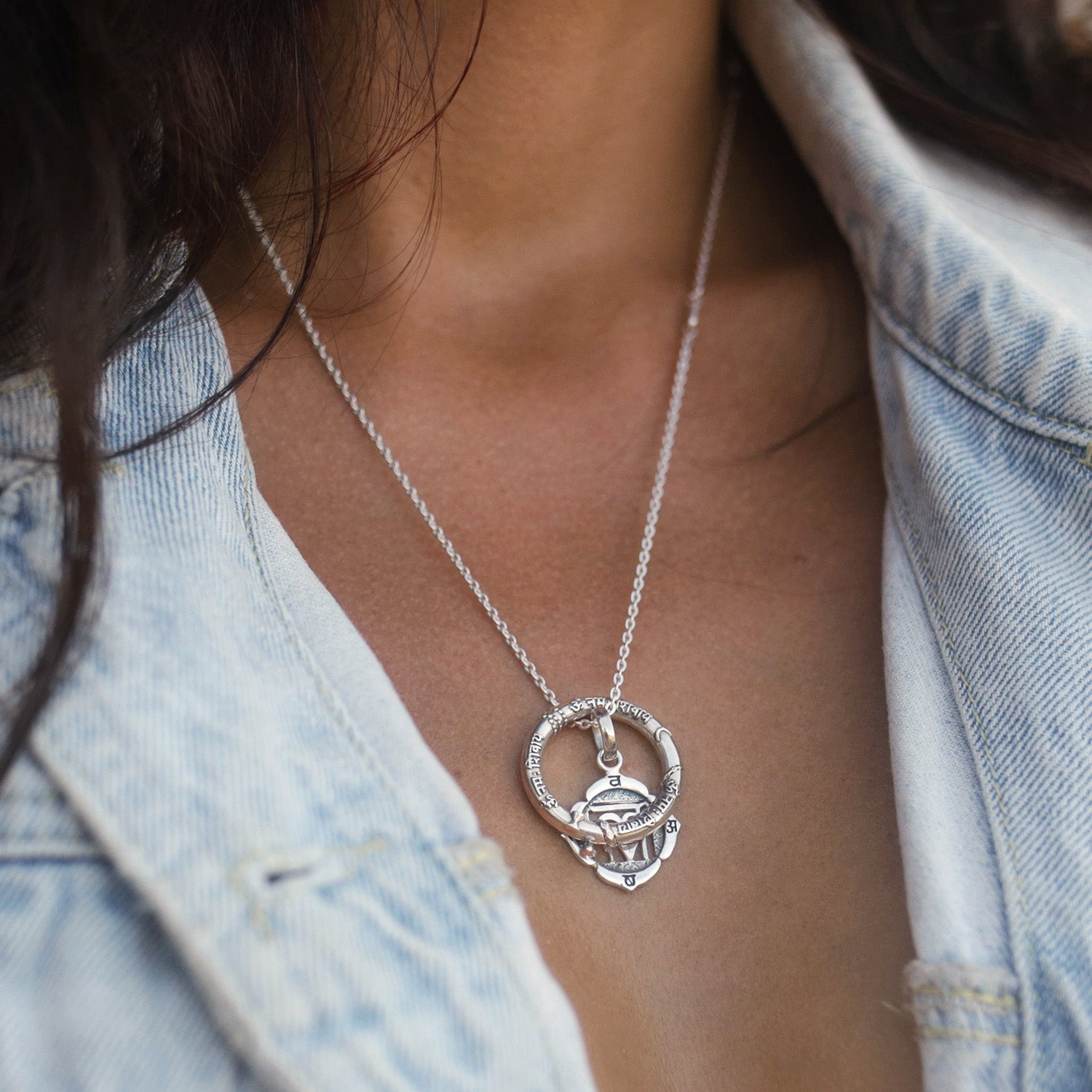 Nahaufnahme von der Balinesischen Yogalehrerin Gianna, die eine silberne Halskette Essenz-des-Seins aus einem Shiva-Mantra- und einem Wurzel-Chakra-Anhänger trägt