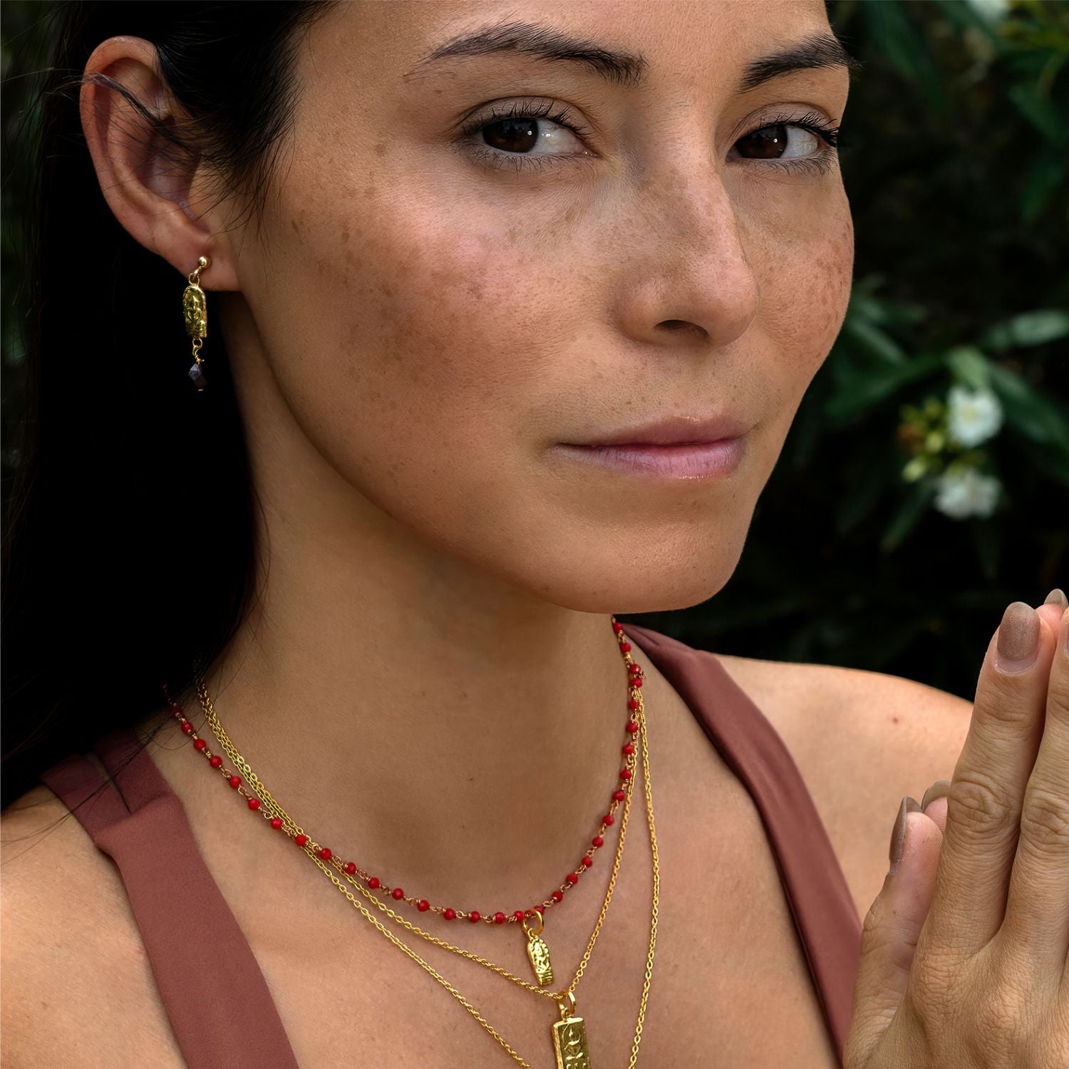 Detailaufnahme: Die Yogalehrerin Steffi trägt ein Buddha Anhänger mini vergoldet aus Sterling Silber zusammen mit aderem hochwertigen Schmuck von ETERNAL BLISS - Spiritueller Schumuck