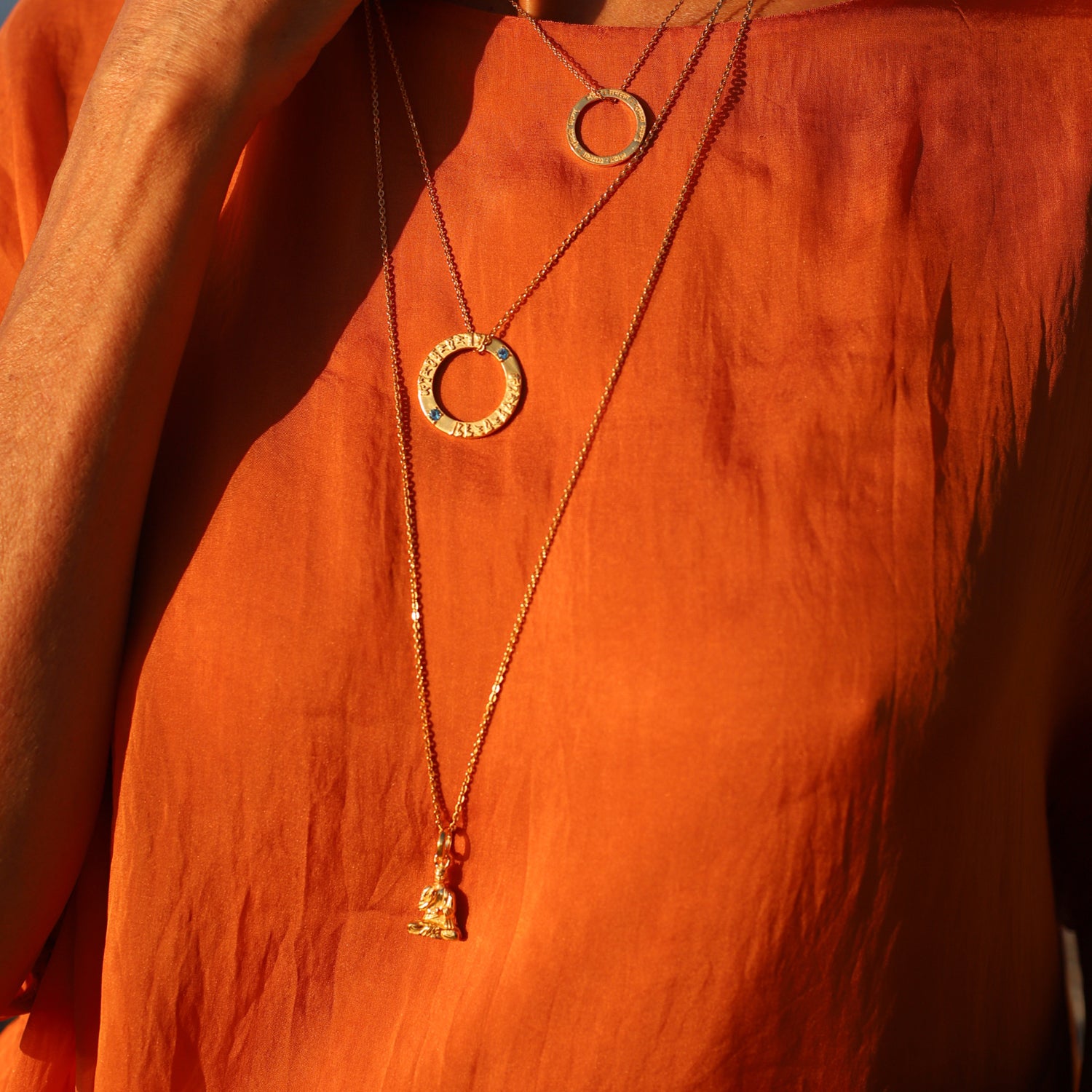 Die Berliner Unternehmerin Cora Schwind trägt einen Lehrender-Buddha-Schmuckanhänger aus vergoldetem Sterling Silber von ETERNAL BLISS - Spiritueller Symbol Schmuck