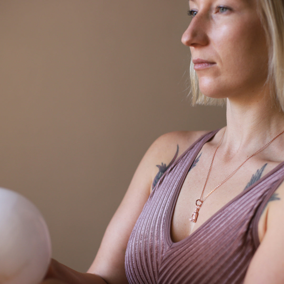 Die Berliner Yoga Lehrerin Maria trägt einen Lehrender-Buddha-Schmuckanhänger aus rosévergoldetem Sterling Silber  vzu ihrer Yoga Session