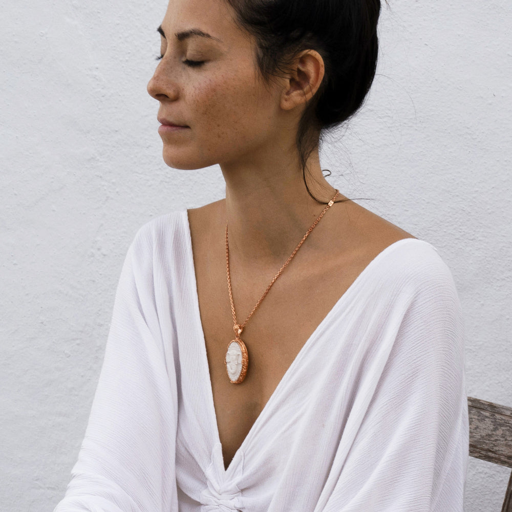Die Yogalehrerin Steffi bei der Meditation, trägt einen hochwertig rosé vergoldeten Ganesha Anhänger mit geschnitztem Einleger und reich verziertem Rahmen mit Om-Emblem auf der Rückseite von ETERNAL BLISS - Spiritueller Schmuck