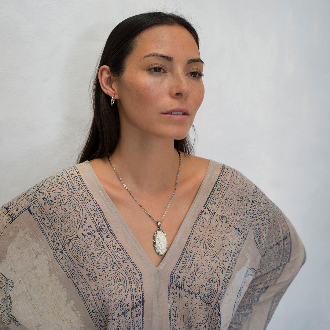 Die Yogalehrerin Steffi, in weißem Gewand, kombiniert einen hochwertigen Ganesha Anhänger mit geschnitztem Einleger und reich verziertem Rahmen aus Sterling Silber an einer kräftigen Halskette  mit Ohrringen von ETERNAL BLISS - Spiritueller Schmuck