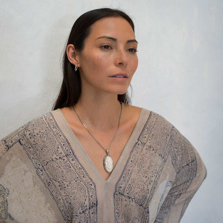 Die Yogalehrerin Steffi, in weißem Gewand, kombiniert einen hochwertigen Ganesha Anhänger mit geschnitztem Einleger und reich verziertem Rahmen aus Sterling Silber an einer kräftigen Halskette  mit Ohrringen von ETERNAL BLISS - Spiritueller Schmuck