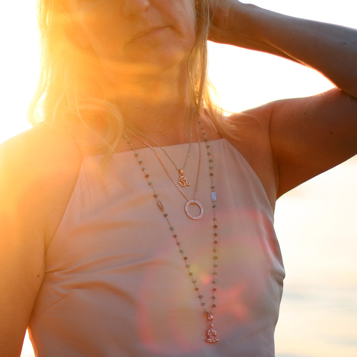 Corinna Marx, Yogalehrerin und Coach in Frankfurt, kombiniert einen großen, rosévergoldeten Gayatri Mantra Anhänger aus Sterling Silber mit verschiedenem spirituellem Schmuck von Eternl Bliss
