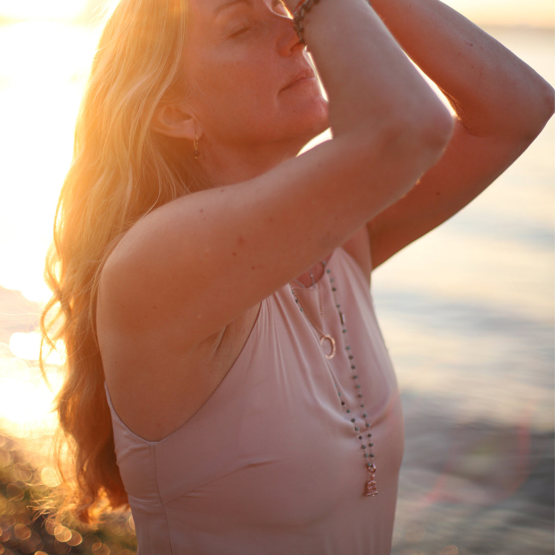 Corinna Marx, Yogalehrerin und Coach in Frankfurt, trägt einen großen, rosévergoldeten Gayatri Mantra Anhänger aus Sterling Silber mit verschiedenem spirituellem Schmuck von Eternl Bliss zu ihrer Yoga Praxis
