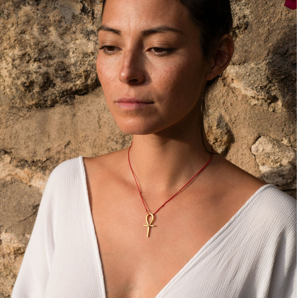 Yoga Teacher Steffi trägt einen hochwertig vergoldeten Ankh-Anhänger mit Rubin von ETERNAL BLISS - Schlüssel des Lebens