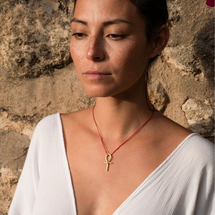 Yoga Teacher Steffi trägt einen hochwertig vergoldeten Ankh-Anhänger mit Rubin von ETERNAL BLISS - Schlüssel des Lebens
