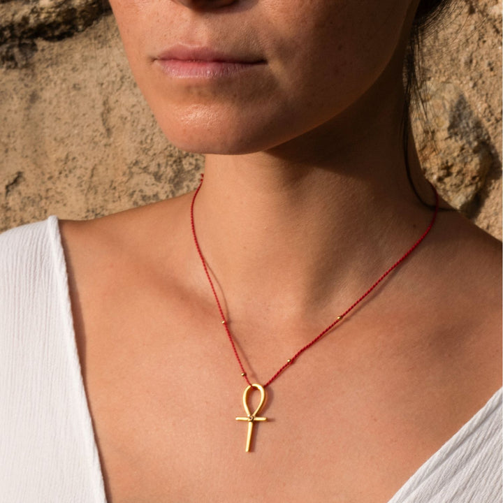 Detailaufnahme von Yoga Teacher Steffi, die einen hochwertig vergoldeten Ankh-Anhänger mit Rubin von ETERNAL BLISS - Schlüssel des Lebens trägt.