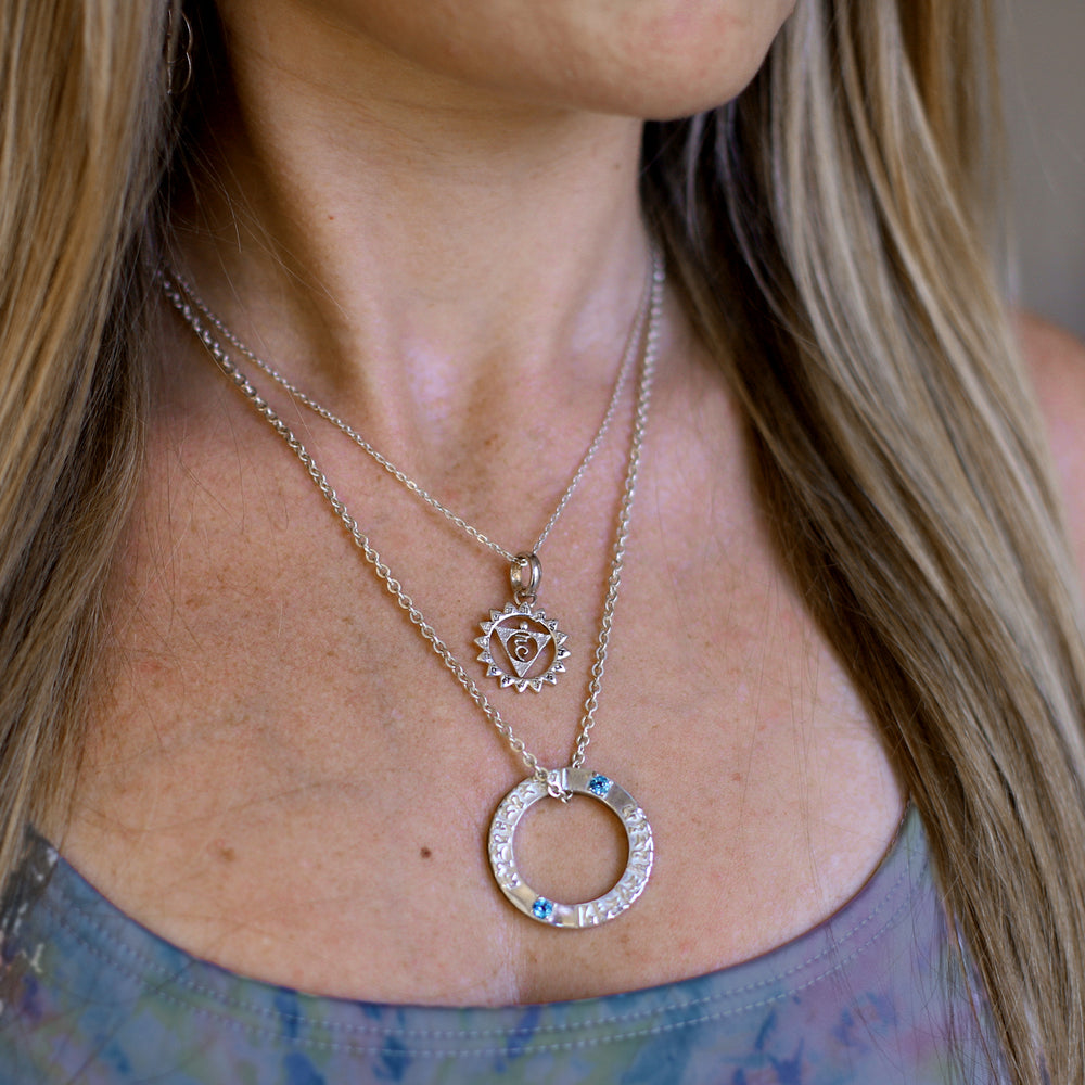 Die Yoga Lehrerin Hedy trägt ein Tara Mantra Anhänger aus Sterling Silber mit Topas Edelstein von ETERNAL BLISS aus der Spirituellen Yoga Schmuckkollektion