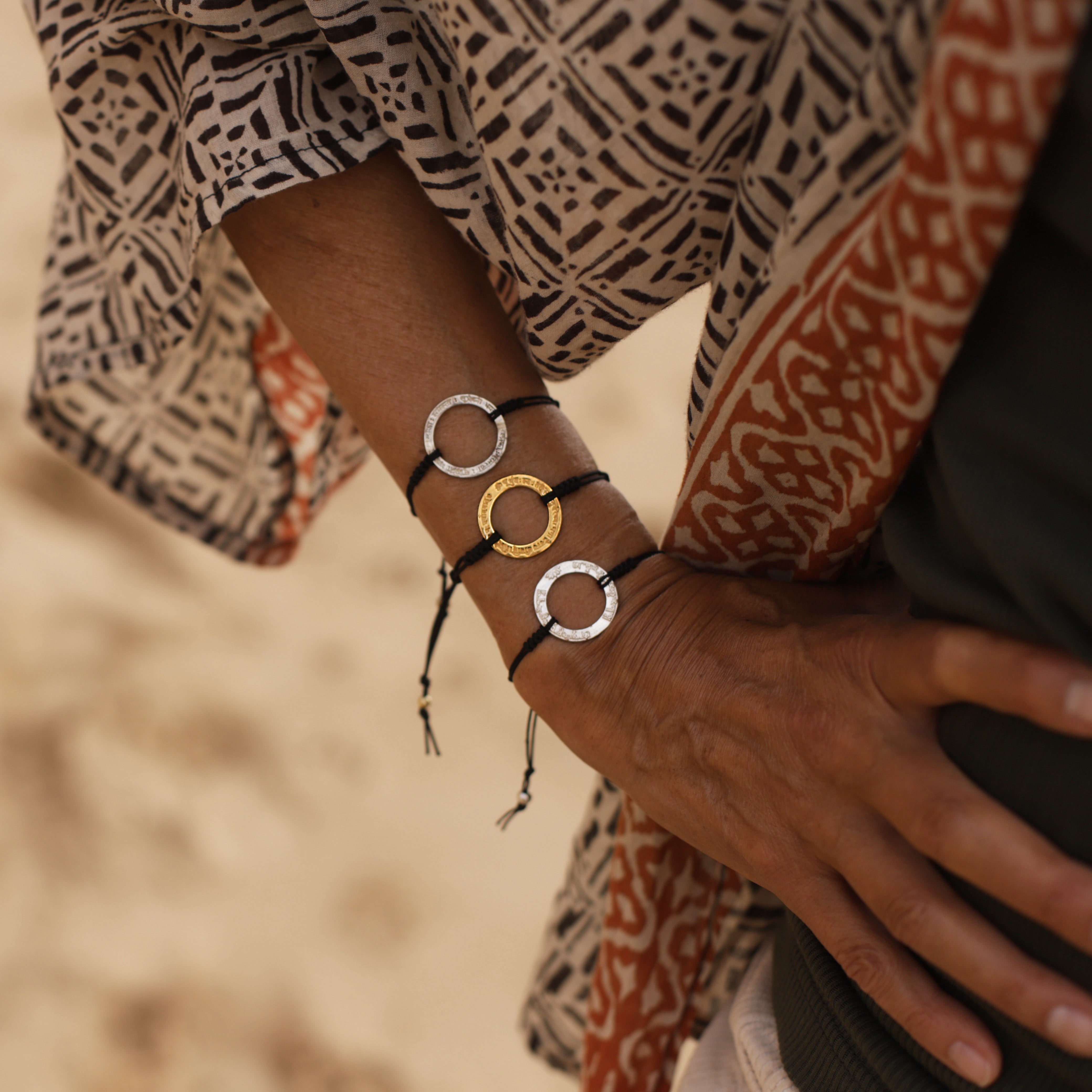 Cora trägt eine Gayatri Mantra Armband in vergoldetem Sterling Silber in Kombination mit 2 silbernen Mantra Armbändern von ETERNAL BLISS