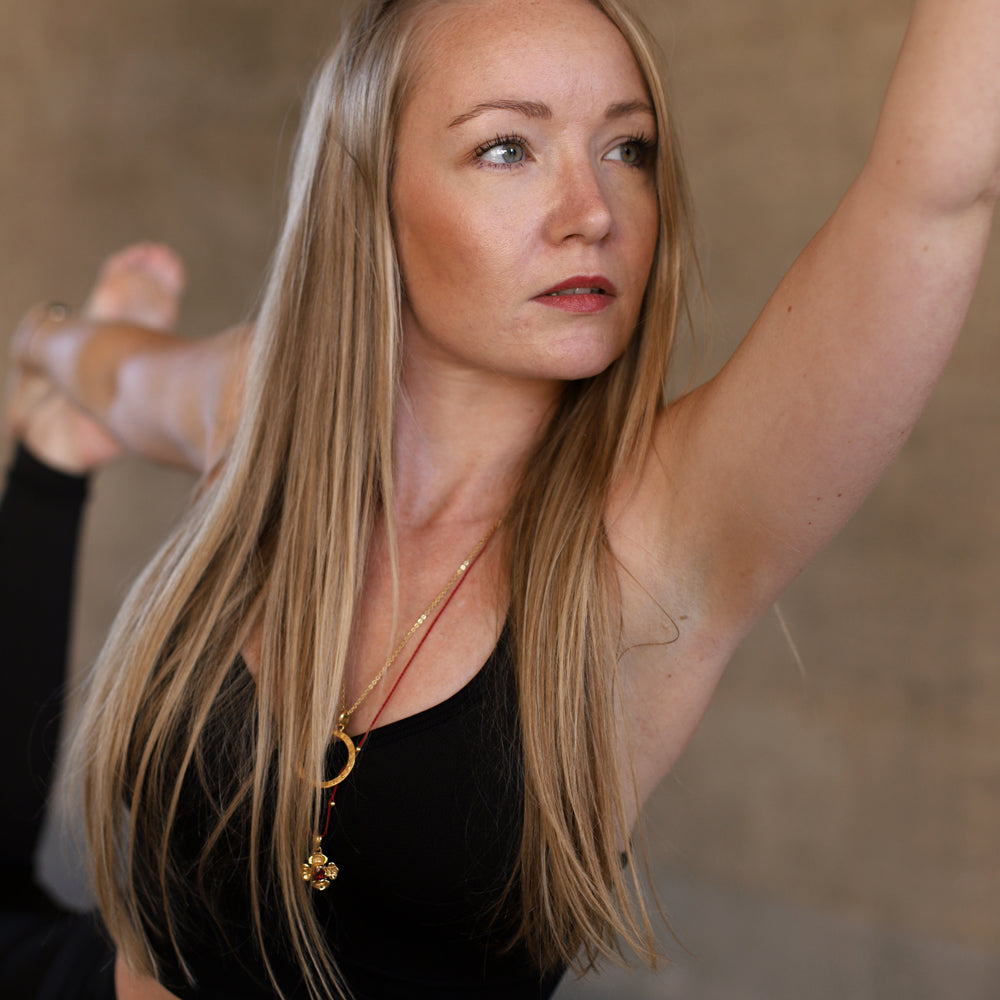 Hedy, Yogalehrerin in Wiesbaden, trägt eine Wurzel Chakra Kette mit einem Granat Edelstein aus hochwertig vergoldetem Sterling Silber von ETERNAL BLISS