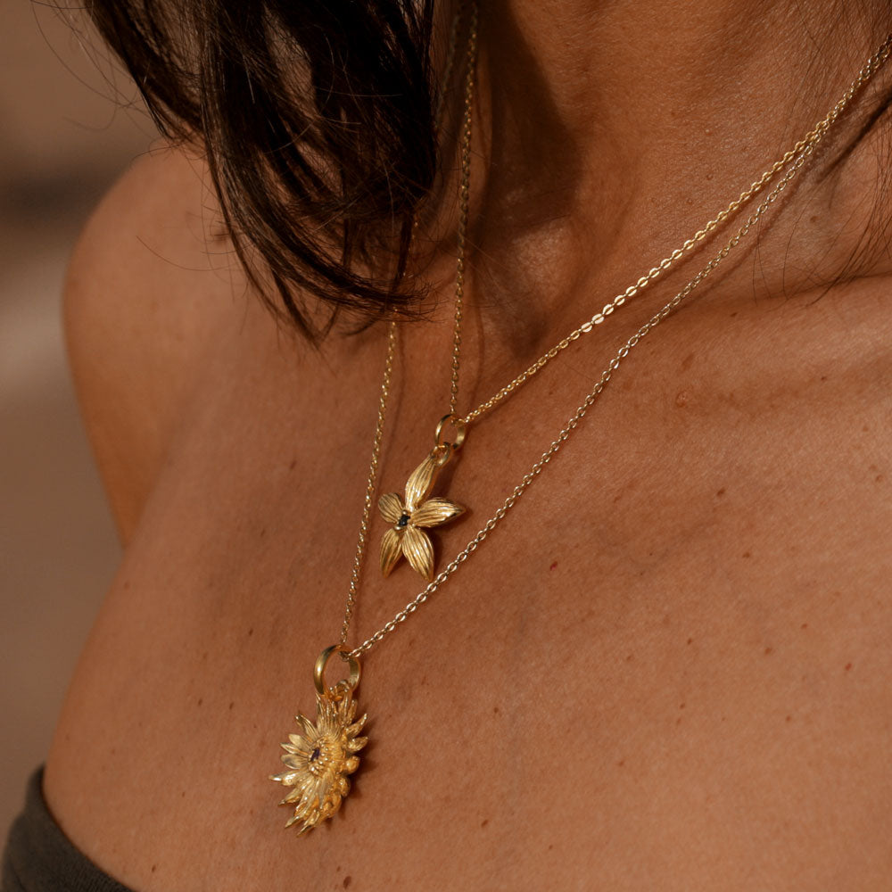 Cora, Inhaberin von ETERNAL BLISS trägt ein Blue China Orchid Anhänger mit Saphir vergoldet mit Kette